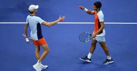 Alcaraz and Jannik Sinner facing off on the tennis court during their intense semi-final match at Indian Wells.]