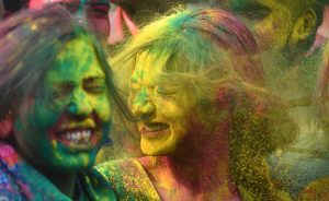 Holi festival colors in bowls with protective skin and hair care products
